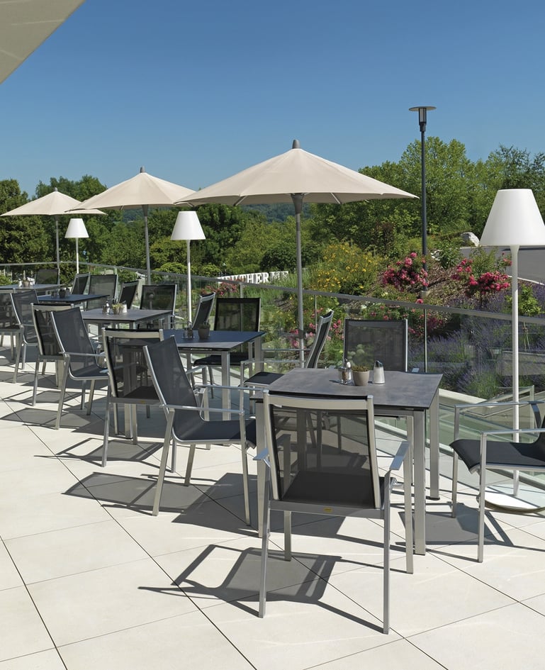 Grosszügige, sonnige Terrasse mit zahlreichen Sitzmöglichkeiten und Tischen sowie Sonnenschirmen