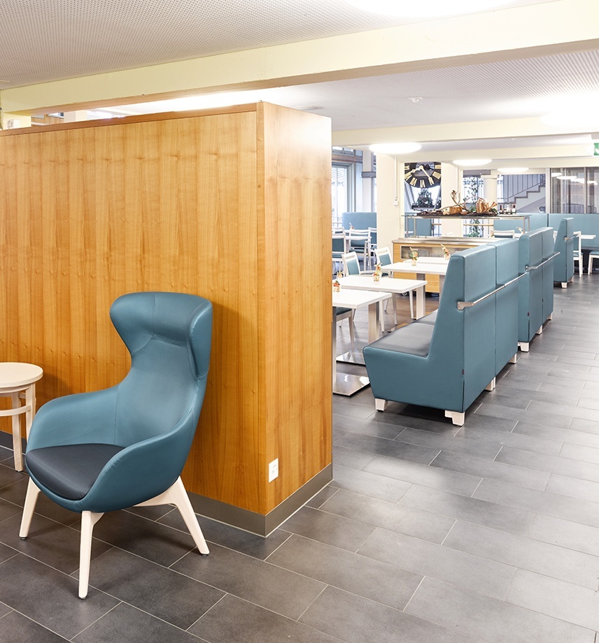 Lichtdurchflutete Caféteria mit eleganten blauen Sesseln 
